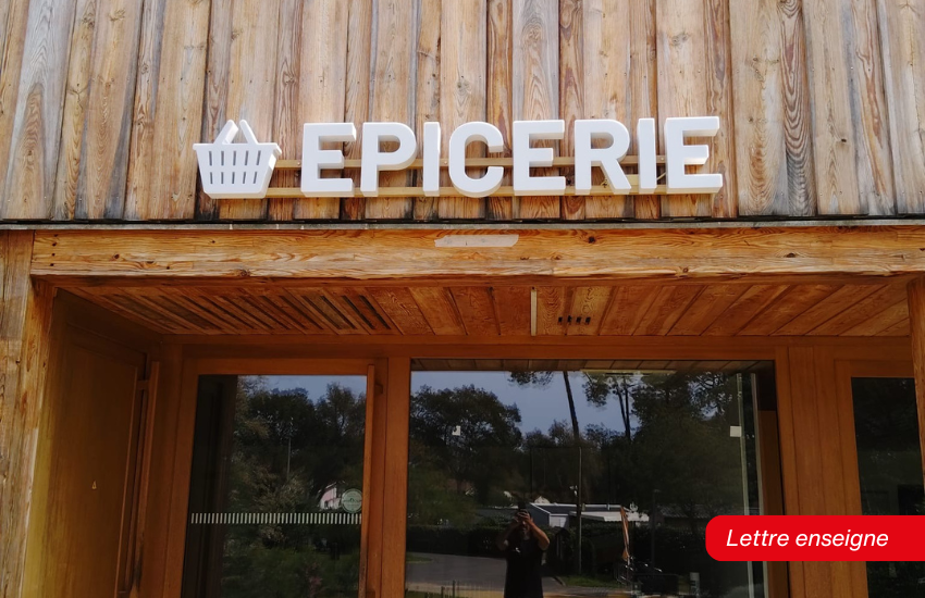 Enseigne en lettres blanches installée pour une épicerie.